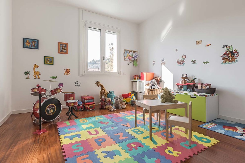 Foto på ett stort funkis könsneutralt barnrum kombinerat med lekrum och för 4-10-åringar, med vita väggar och mörkt trägolv