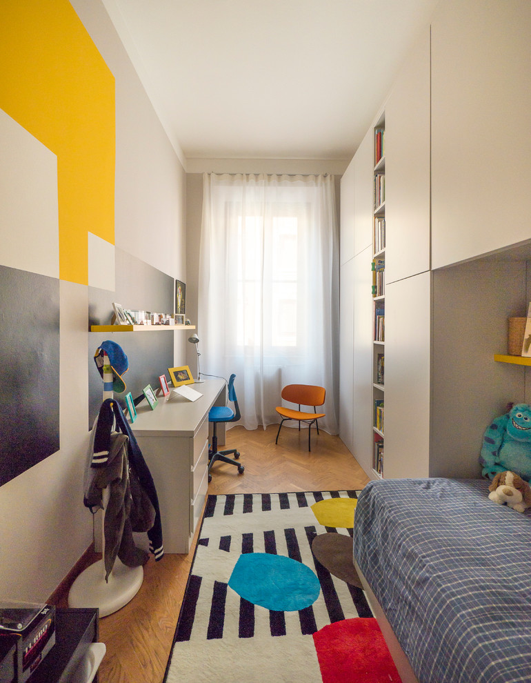 Immagine di una piccola cameretta per bambini da 4 a 10 anni minimal con pareti multicolore e parquet chiaro