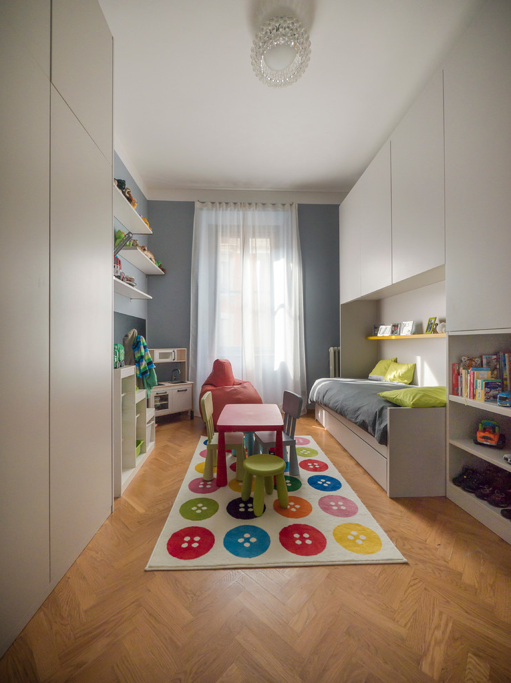Esempio di una grande cameretta per bambini da 4 a 10 anni minimal con pareti blu e parquet chiaro
