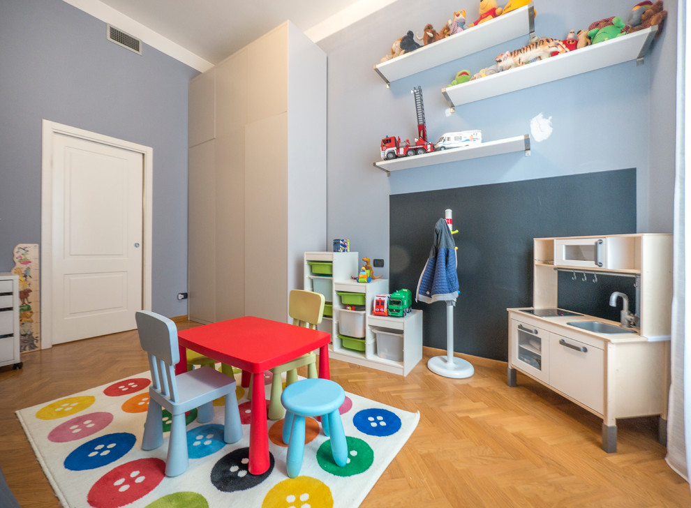Esempio di una grande cameretta per bambini da 4 a 10 anni design con pareti blu e parquet chiaro