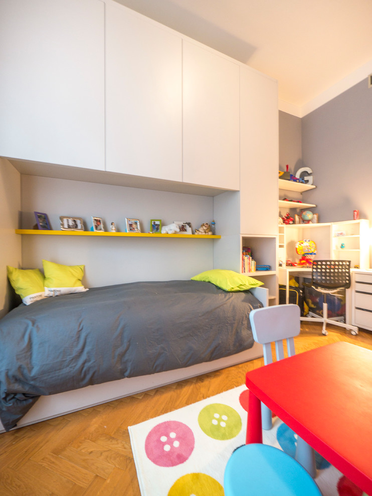 Idée de décoration pour une grande chambre d'enfant de 4 à 10 ans design avec un mur bleu et parquet clair.