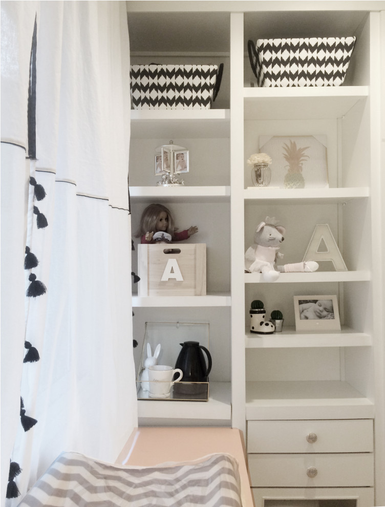 Modelo de dormitorio infantil de 1 a 3 años moderno pequeño con paredes blancas y suelo de madera en tonos medios