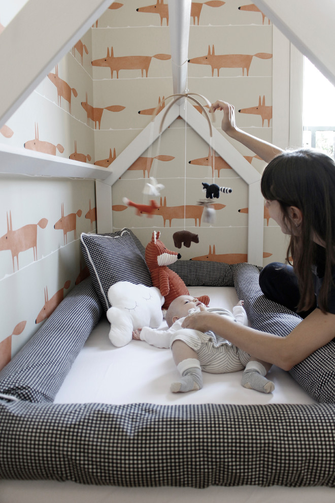 Inspiration pour une chambre d'enfant de 1 à 3 ans ethnique de taille moyenne avec un mur multicolore et un sol en bois brun.