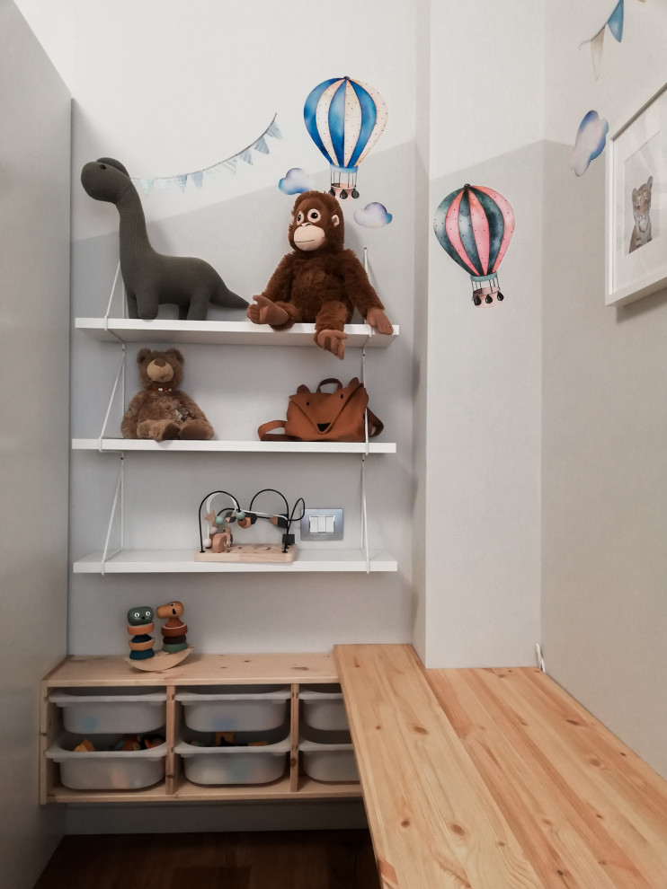 Idée de décoration pour une chambre d'enfant de 1 à 3 ans design de taille moyenne avec un mur bleu et parquet clair.