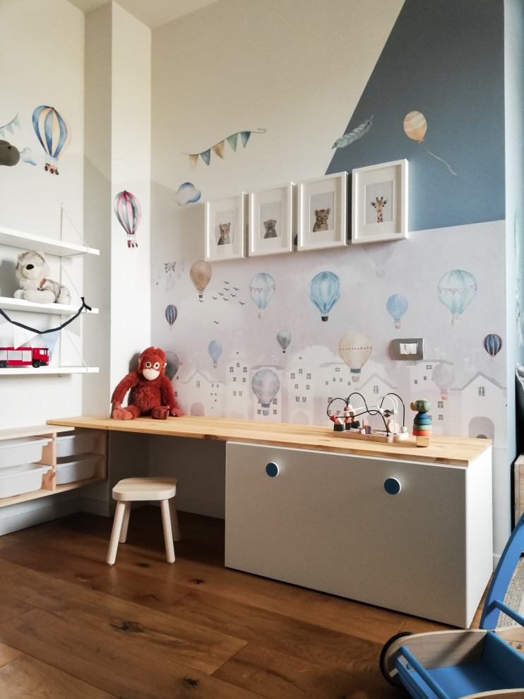 Ispirazione per una cameretta per bambini da 1 a 3 anni design di medie dimensioni con pareti blu e parquet chiaro