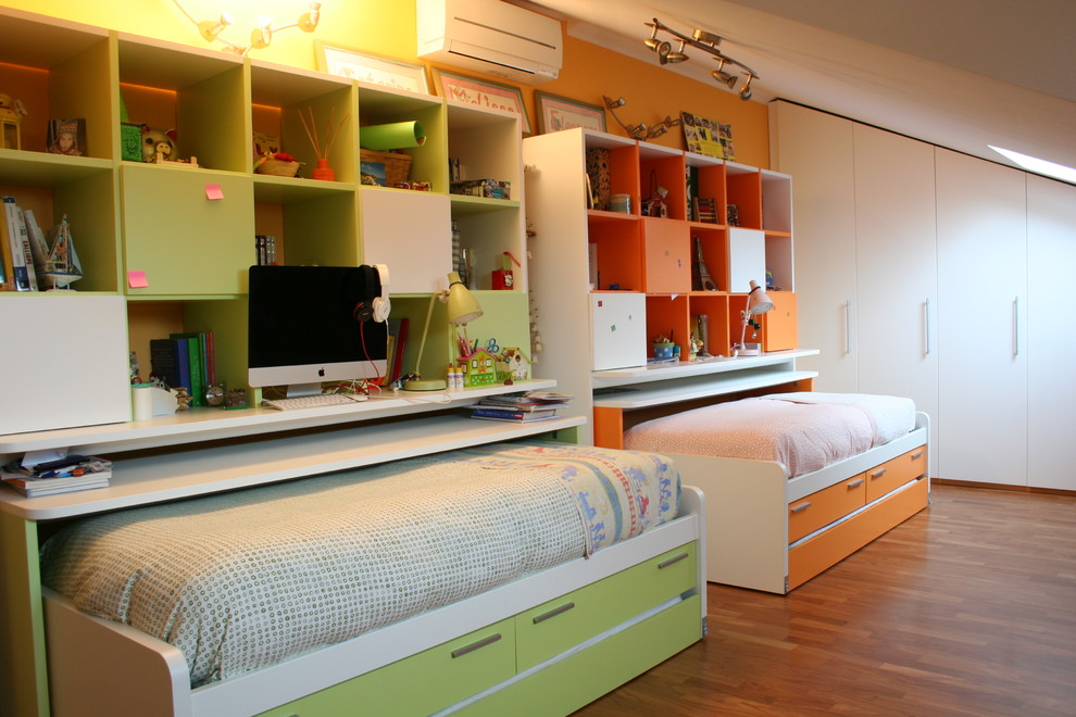 Immagine di una cameretta neutra design con pavimento in legno massello medio