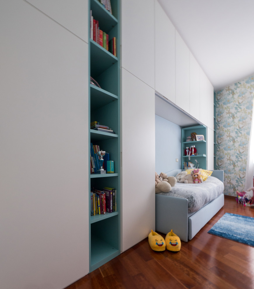Foto på ett mellanstort funkis barnrum kombinerat med sovrum, med blå väggar och mellanmörkt trägolv