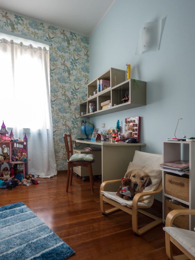 Esempio di una cameretta per bambini minimal di medie dimensioni con pareti blu e pavimento in legno massello medio