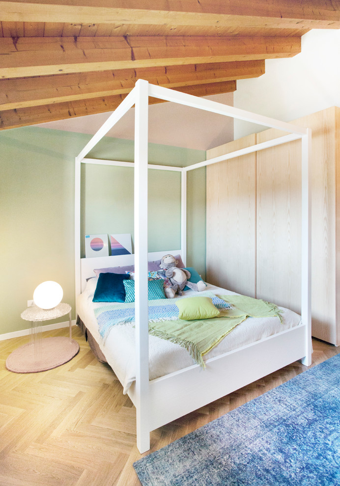Minimalistisk inredning av ett könsneutralt tonårsrum kombinerat med sovrum, med gröna väggar, ljust trägolv och beiget golv