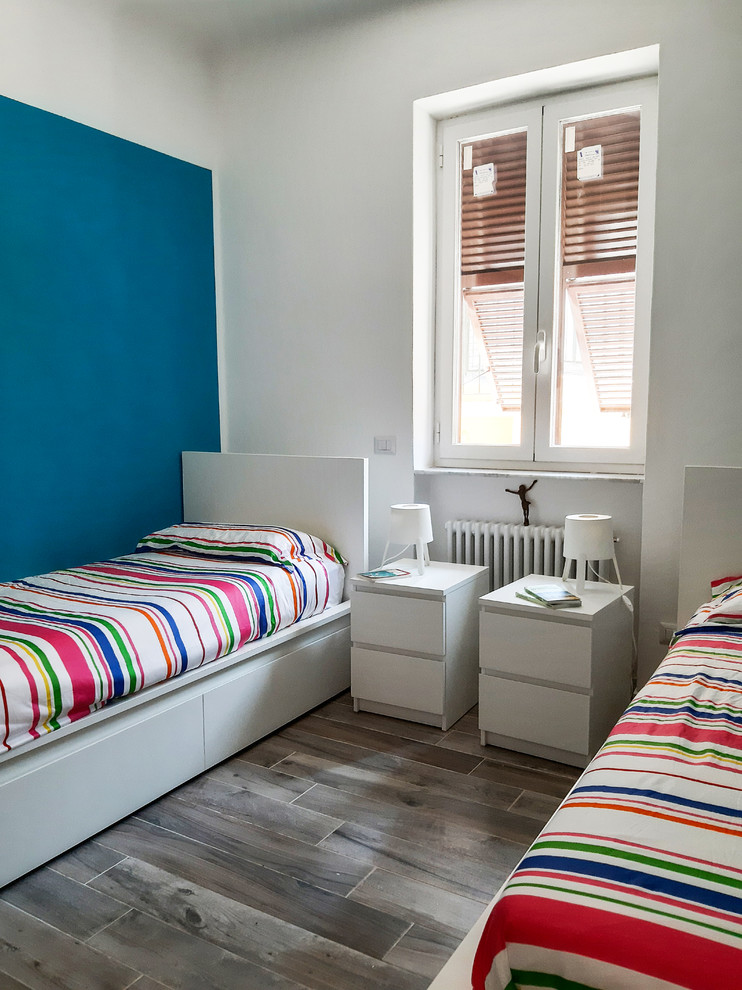 This is an example of a medium sized contemporary gender neutral children’s room in Other with blue walls, porcelain flooring and brown floors.