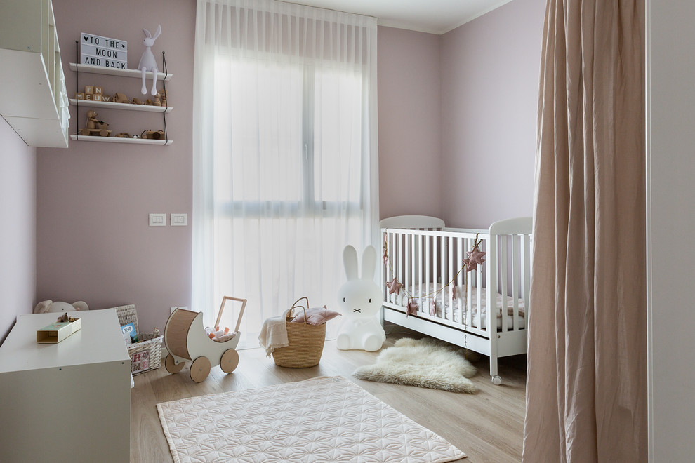На фото: комната для малыша среднего размера в стиле модернизм с розовыми стенами и светлым паркетным полом для девочки с