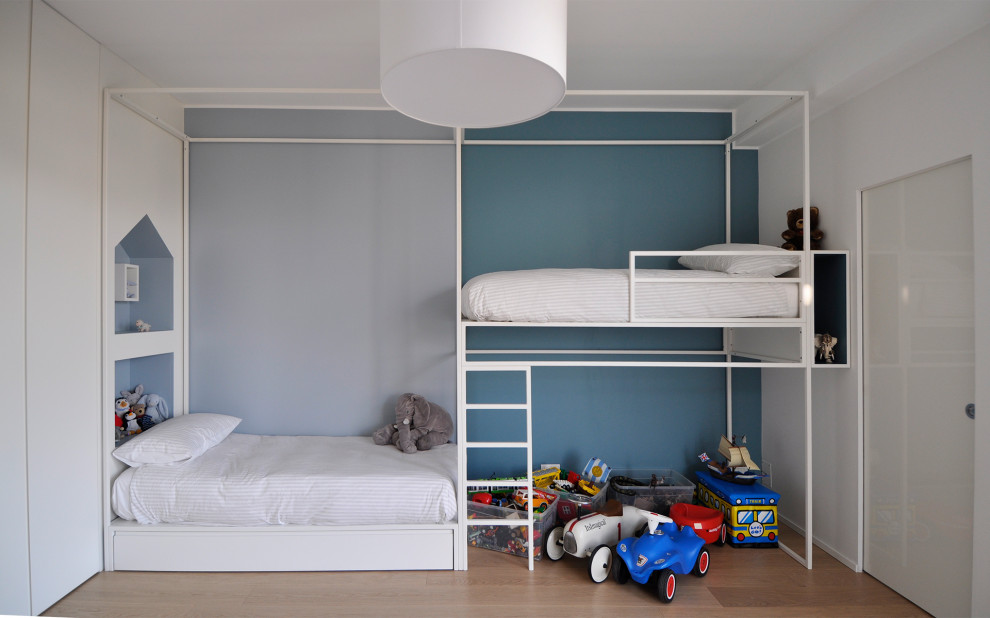 Idee per una cameretta per bambini da 4 a 10 anni minimal con pareti blu, pavimento in legno massello medio e pavimento marrone