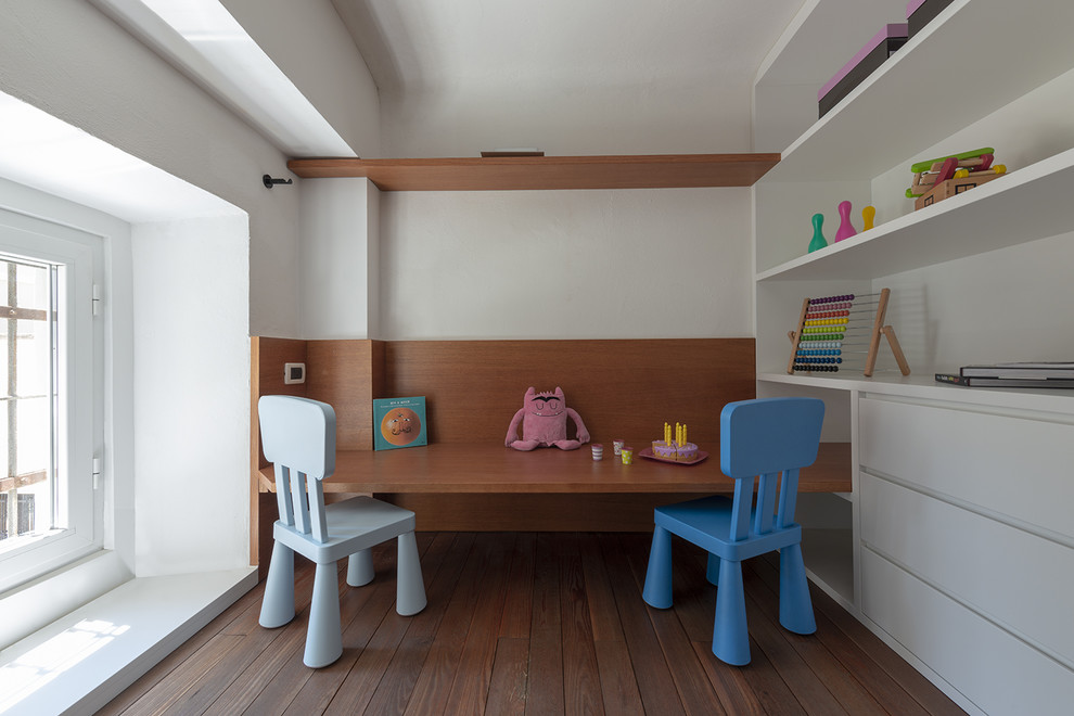 Esempio di una piccola cameretta per bambini da 4 a 10 anni minimalista con pareti bianche, parquet scuro e pavimento marrone