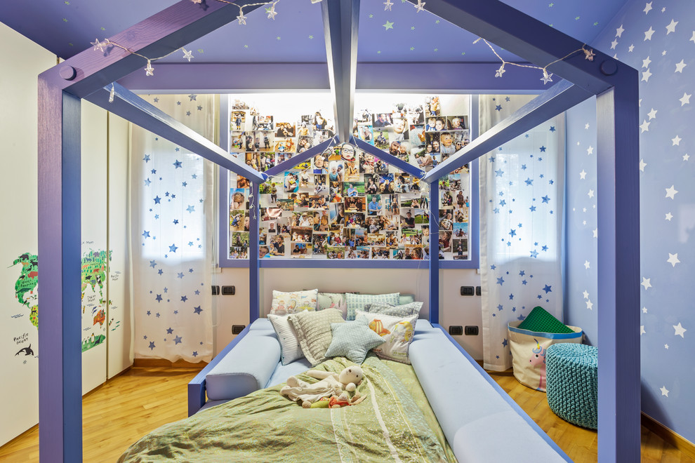 Modernes Mädchenzimmer mit Schlafplatz, blauer Wandfarbe, braunem Holzboden und braunem Boden in Venedig