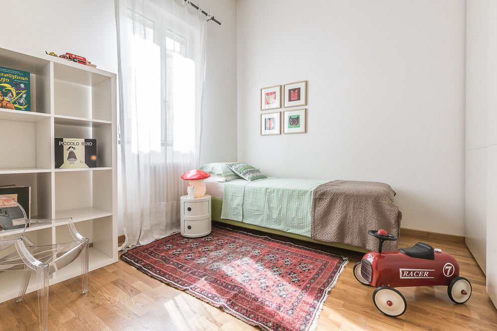 Imagen de dormitorio infantil de 4 a 10 años moderno grande con paredes blancas y suelo de madera en tonos medios
