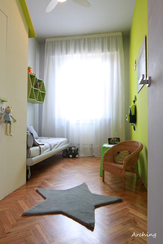 Esempio di una piccola cameretta per bambini da 4 a 10 anni contemporanea con parquet chiaro e pareti verdi