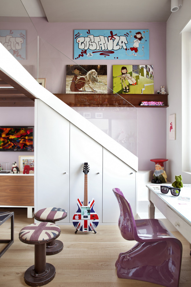 Esempio di una cameretta da bambina design con pareti viola e parquet chiaro