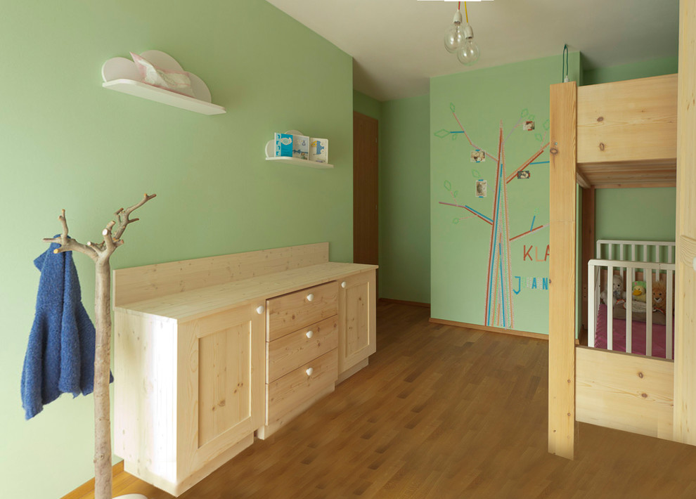 Idéer för att renovera ett litet funkis barnrum kombinerat med sovrum, med gröna väggar och mellanmörkt trägolv