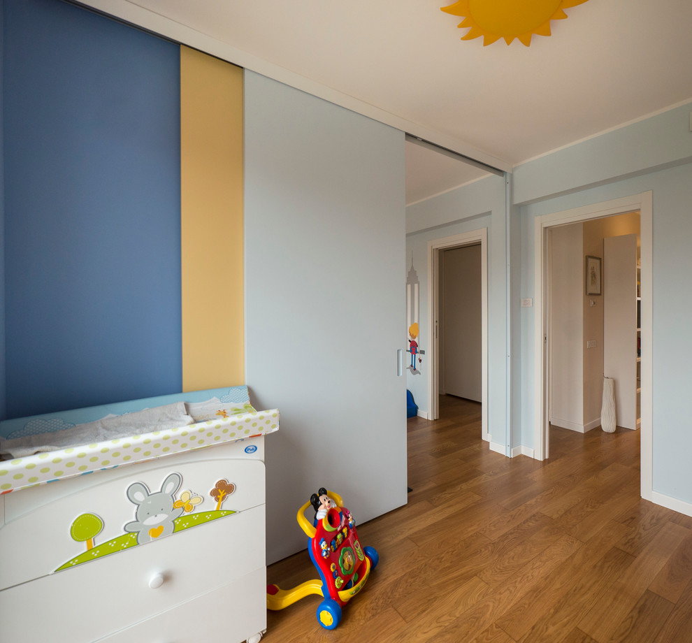 Exempel på ett mellanstort modernt pojkrum kombinerat med sovrum och för 4-10-åringar, med blå väggar och ljust trägolv