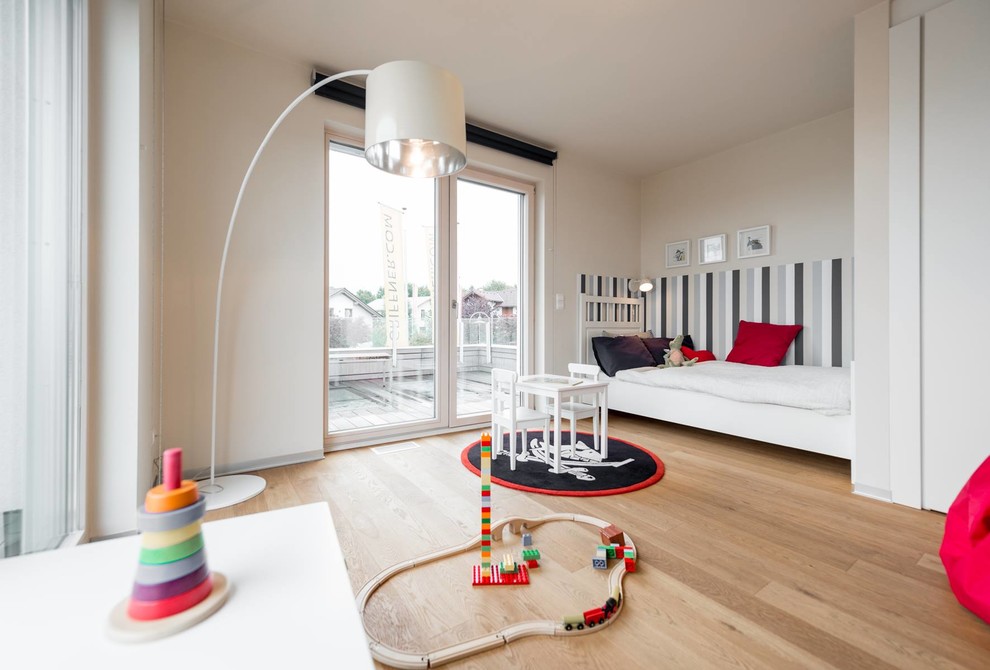 This is an example of a medium sized scandi gender neutral children’s room in Venice with beige walls, medium hardwood flooring and brown floors.