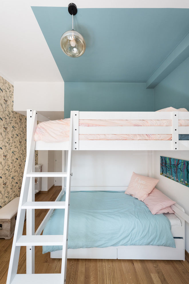 Exempel på ett modernt barnrum kombinerat med sovrum, med blå väggar, mellanmörkt trägolv och brunt golv