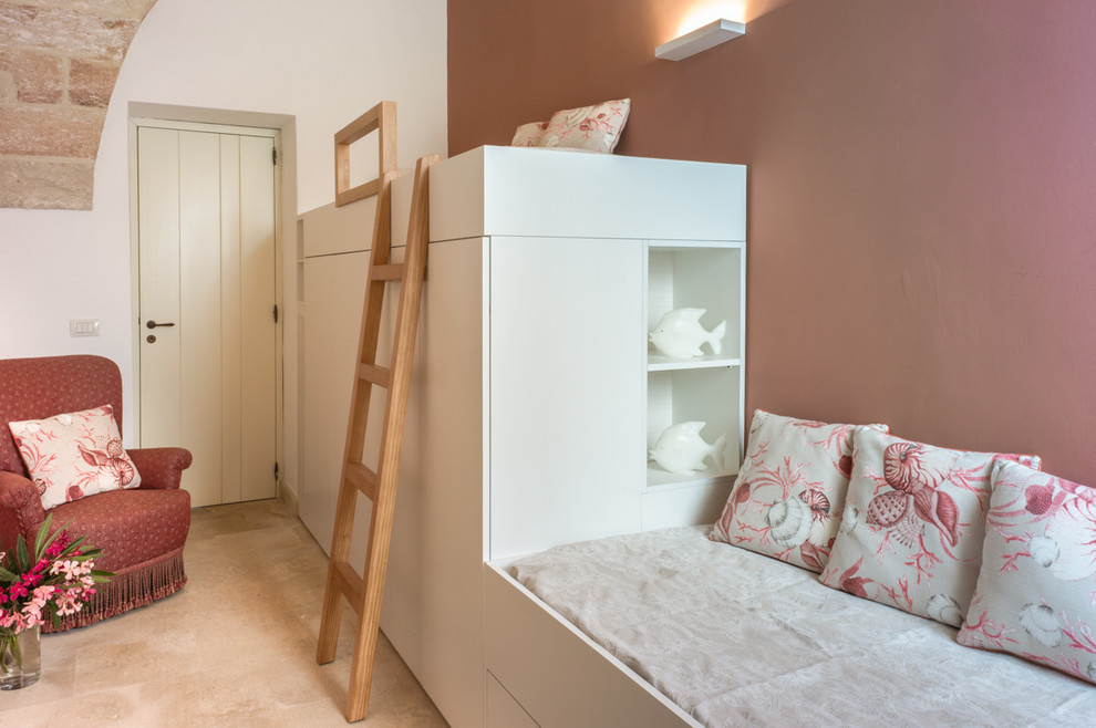 This is an example of a mediterranean children’s room for girls in Other with pink walls and beige floors.