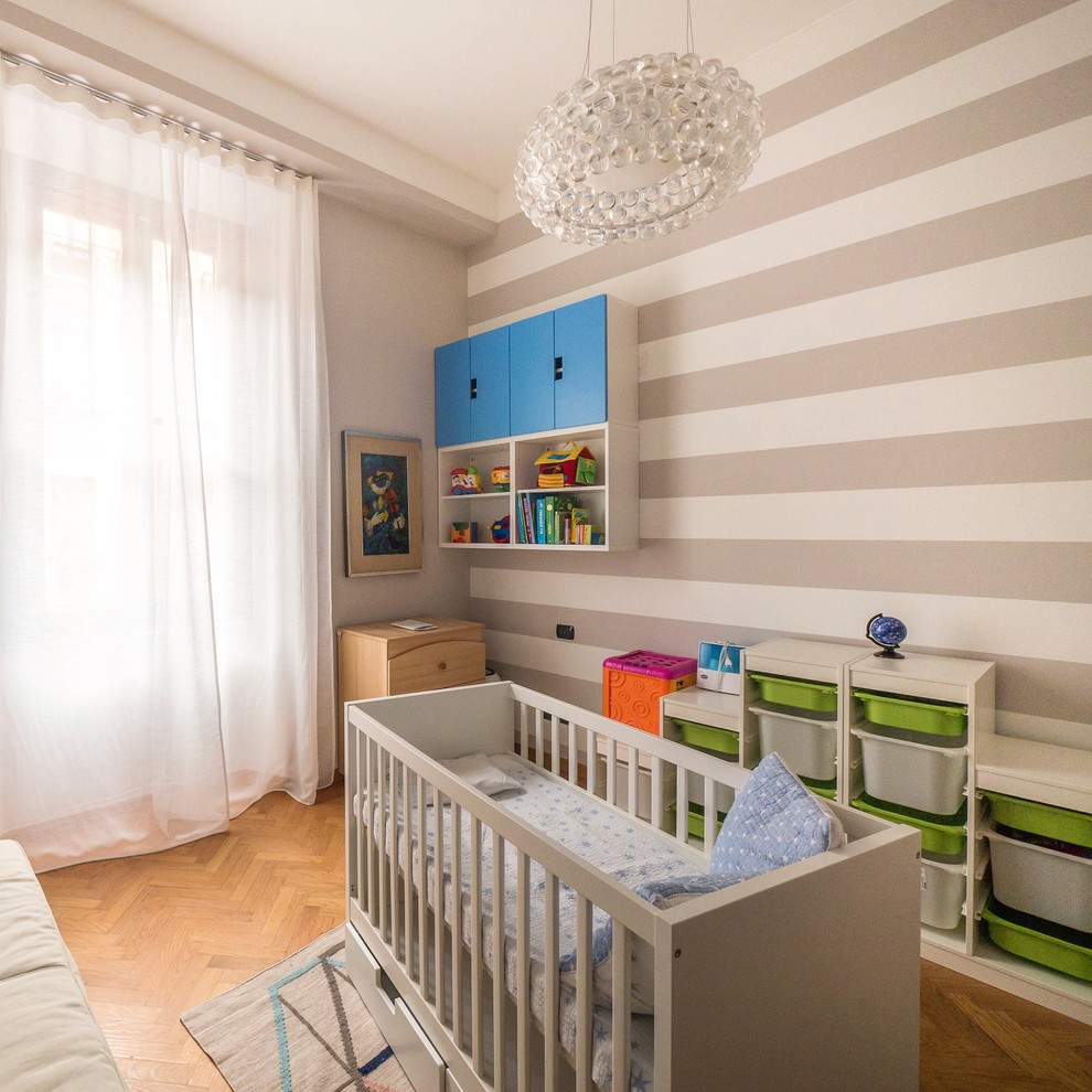 На фото: детская среднего размера в современном стиле с спальным местом, серыми стенами, паркетным полом среднего тона и коричневым полом для ребенка от 1 до 3 лет, мальчика с