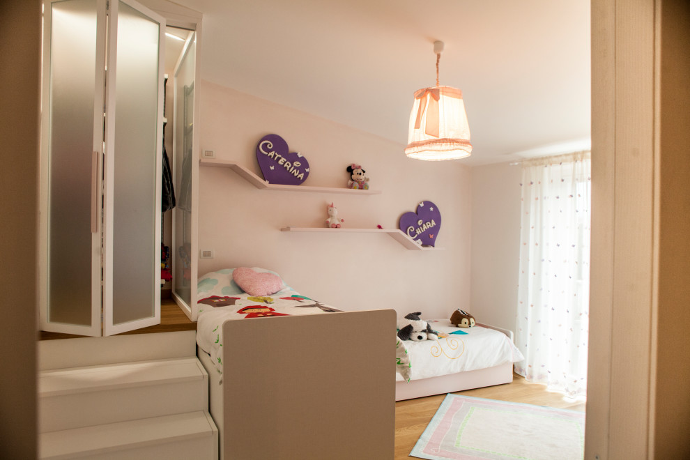 Geräumiges Modernes Mädchenzimmer mit Schlafplatz, rosa Wandfarbe, braunem Holzboden und braunem Boden in Rom