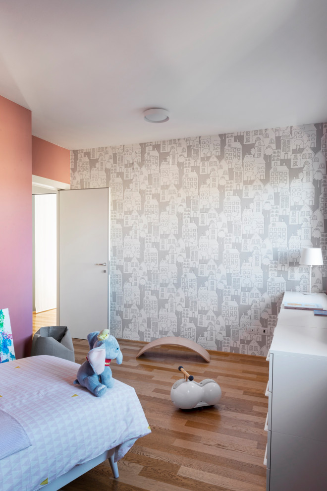 Inspiration for a small contemporary kids' bedroom for girls in Milan with pink walls and light hardwood flooring.