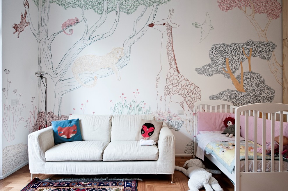 Medium sized scandinavian toddler’s room for girls in Milan with medium hardwood flooring, multi-coloured walls and brown floors.