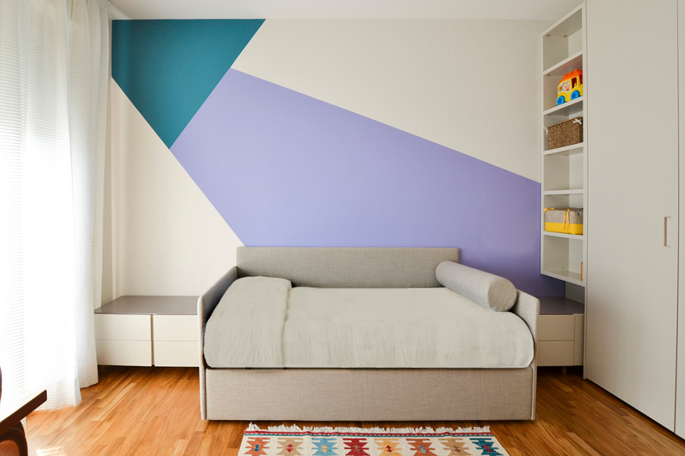 This is an example of a contemporary children’s room in Milan with light hardwood flooring.