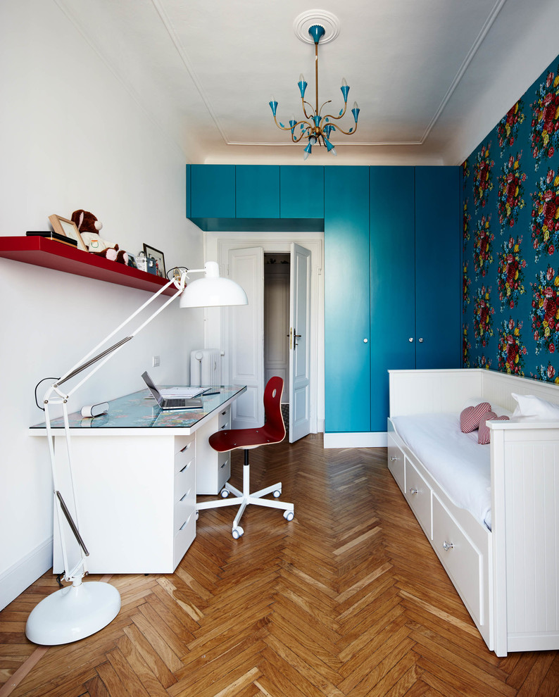Immagine di una cameretta per bambini classica con pareti bianche, pavimento in legno massello medio e pavimento marrone