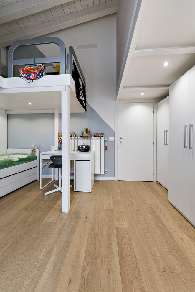 Ejemplo de dormitorio infantil de 4 a 10 años actual de tamaño medio con paredes multicolor, suelo de madera clara y suelo beige