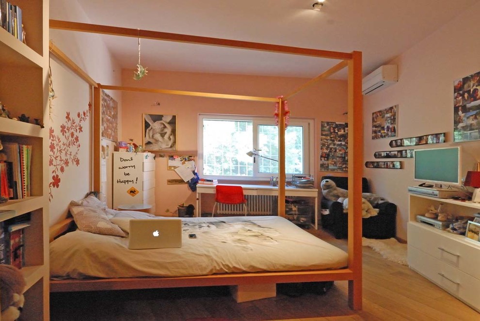 Immagine di una cameretta da letto minimalista con pareti bianche e pavimento in legno massello medio