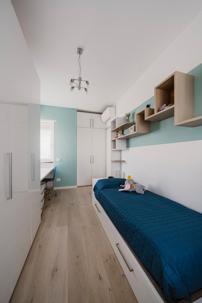 Imagen de dormitorio infantil moderno pequeño con paredes multicolor, suelo de madera clara y suelo beige