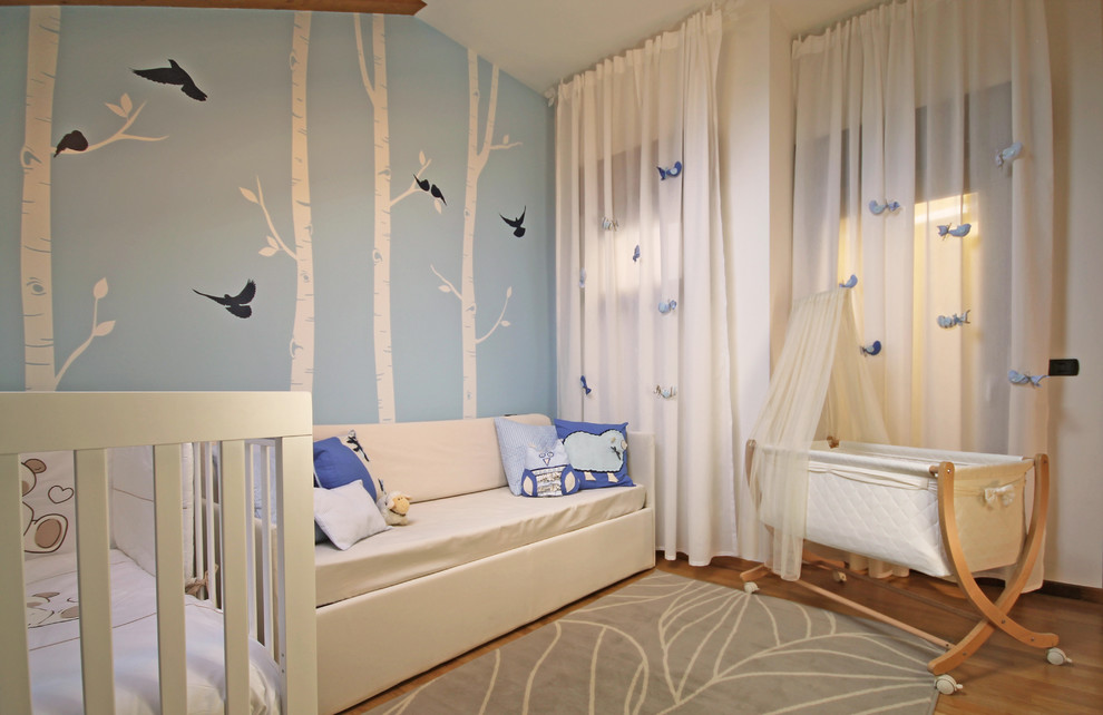 Immagine di una grande cameretta per bambini moderna con pareti blu, parquet chiaro e pavimento marrone