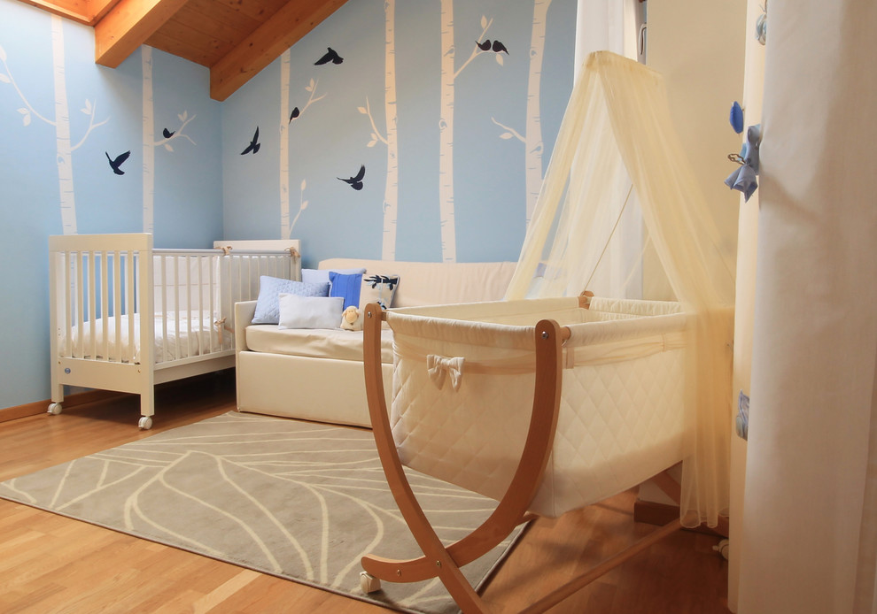 Ispirazione per una cameretta da letto contemporanea con pareti blu, parquet chiaro e pavimento marrone
