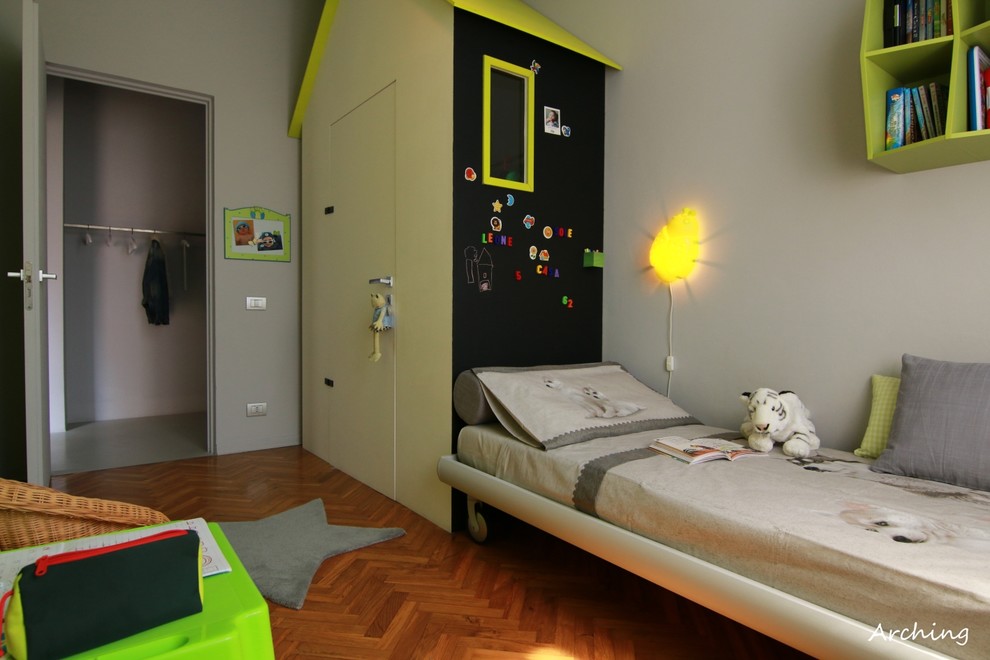 Example of a mid-sized minimalist gender-neutral light wood floor kids' room design in Milan with green walls