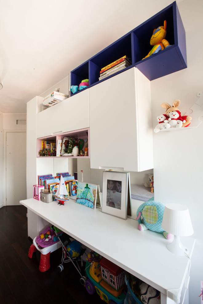Esempio di una cameretta per bambini da 4 a 10 anni minimalista di medie dimensioni con pareti bianche e parquet scuro