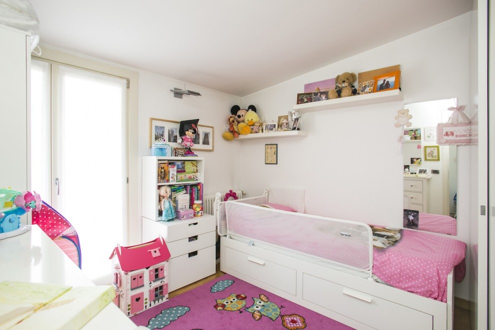 Diseño de dormitorio infantil de 4 a 10 años moderno pequeño con paredes blancas y suelo de madera clara