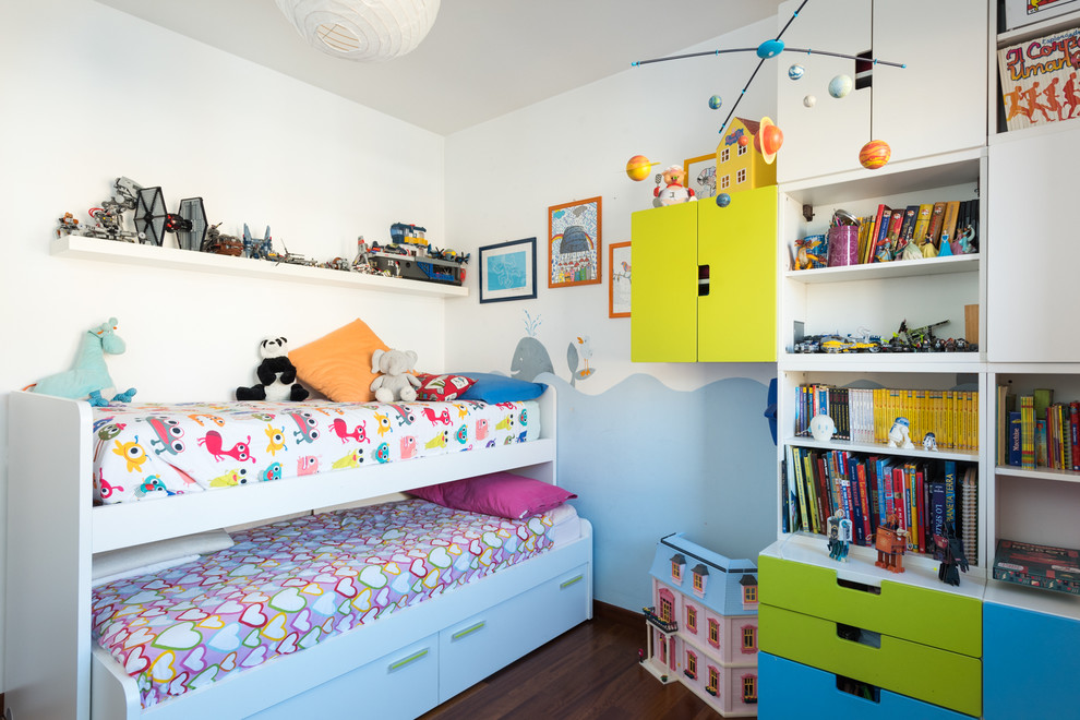 This is an example of a small contemporary gender neutral children’s room in Rome with white walls and medium hardwood flooring.