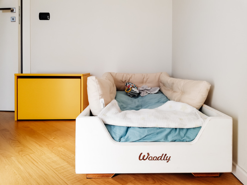 Ispirazione per una piccola cameretta per neonato minimalista con pareti bianche e parquet chiaro