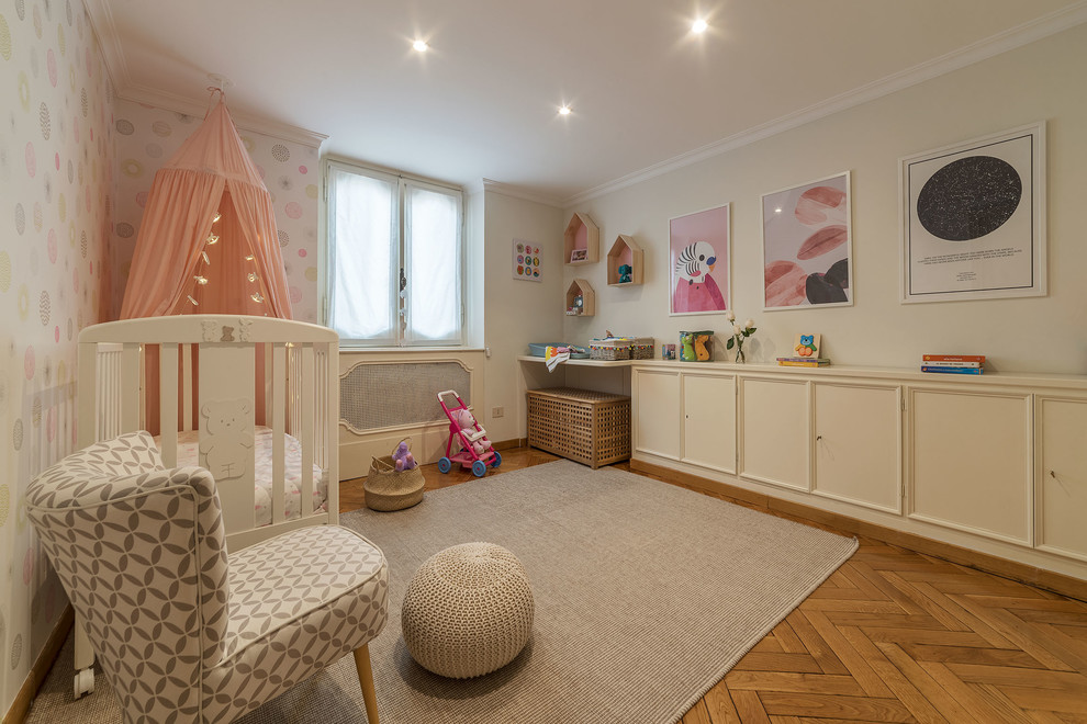 Immagine di una cameretta per neonata scandinava con pareti rosa