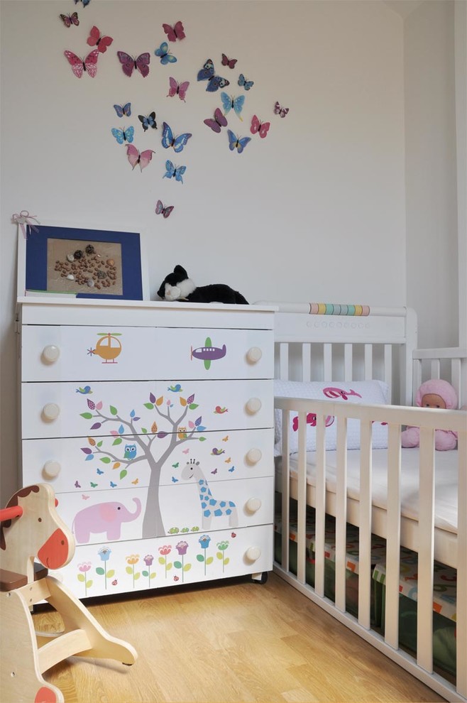 Inspiration pour une petite chambre de bébé neutre minimaliste avec un mur blanc et parquet clair.