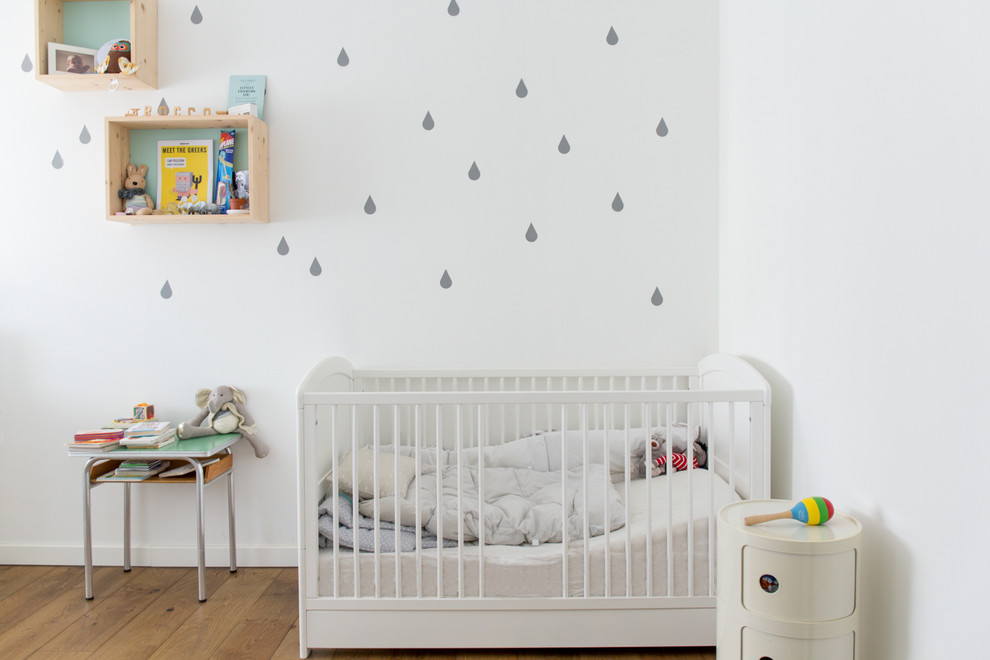 Neutrales Skandinavisches Babyzimmer mit weißer Wandfarbe, braunem Holzboden und braunem Boden in Venedig