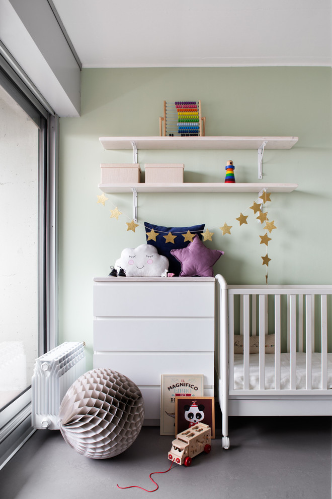 Exemple d'une chambre de bébé neutre tendance de taille moyenne avec un mur vert, sol en béton ciré et un sol gris.
