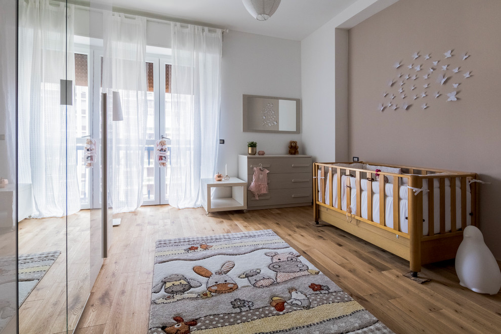 На фото: нейтральная комната для малыша среднего размера в стиле неоклассика (современная классика) с разноцветными стенами, паркетным полом среднего тона и коричневым полом