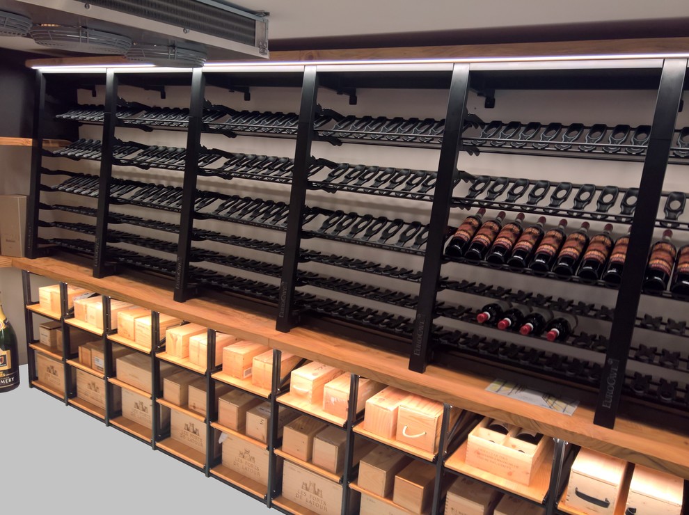 This is an example of a medium sized retro wine cellar in Turin with display racks.