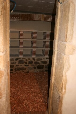 Idées déco pour une petite cave à vin classique avec un sol en brique, des casiers et un sol rouge.