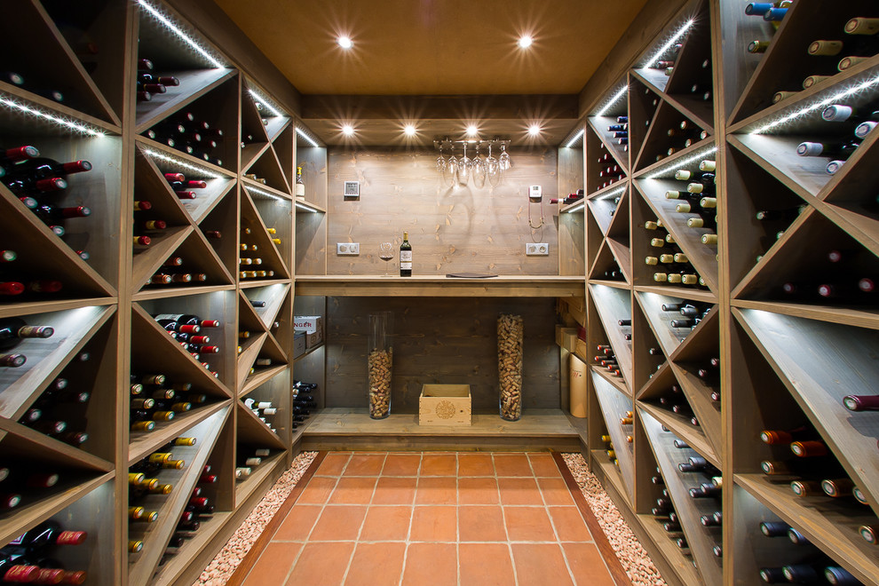 Idéer för stora funkis vinkällare, med klinkergolv i terrakotta och vinställ med diagonal vinförvaring